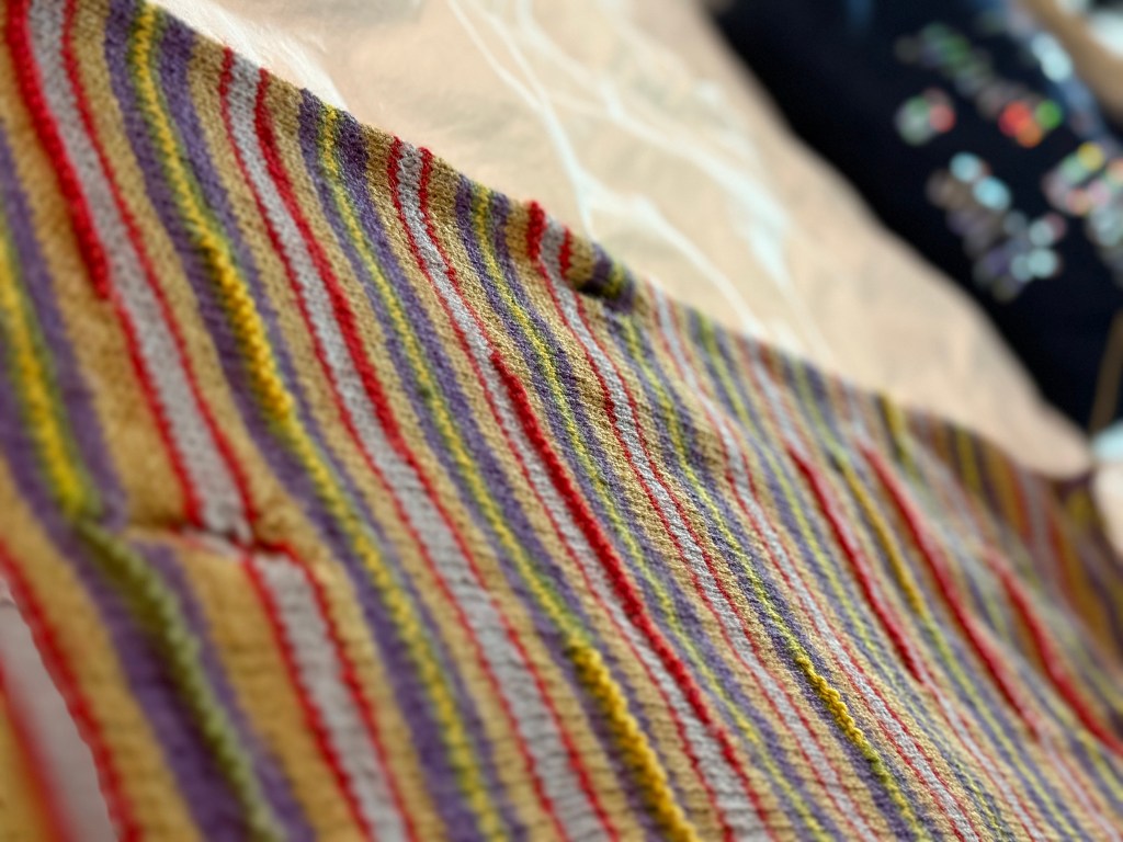 A slightly angled view of the scarf showcasing its consistent striping and texture, with the background softly blurred.
